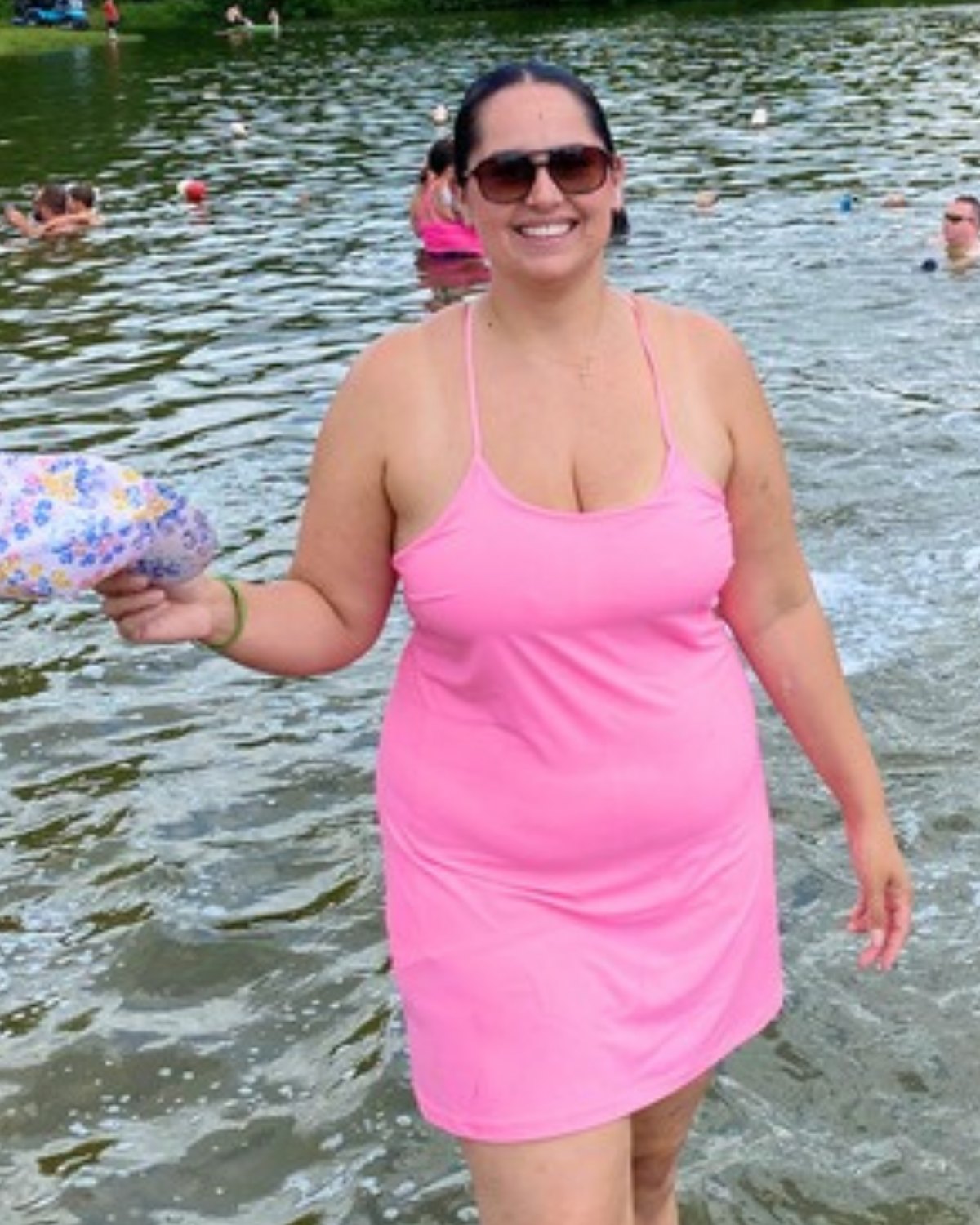 Dra. Amanda Perez before, standing in a lake in a pink dress